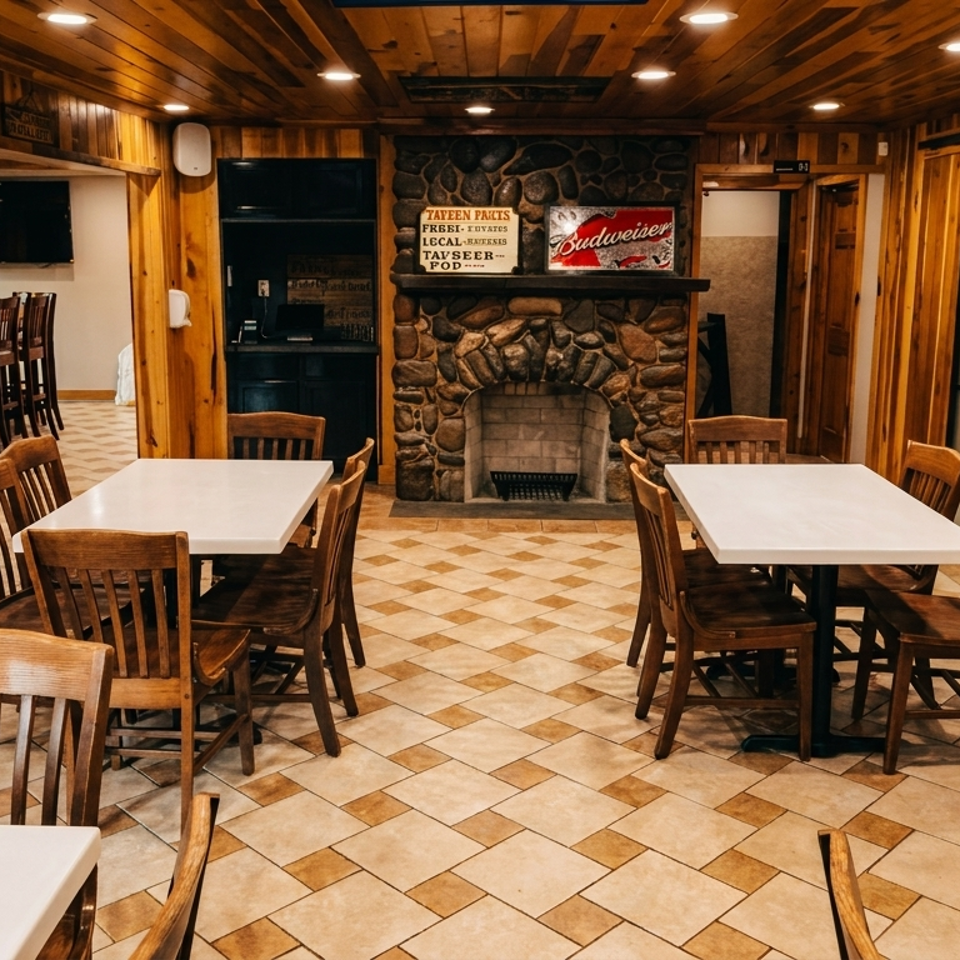 Cozy restaurant interior with wood paneling, tiled floor, white tables, wooden chairs, and a stone fireplace.
